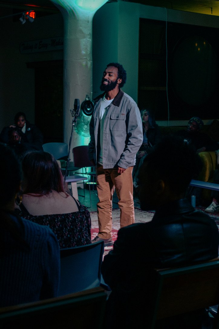 A speaker at the microphone in front of a seated audience at a Tiny SMS talk